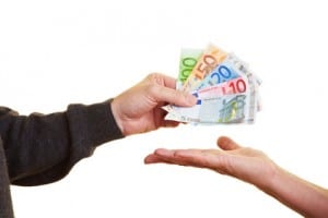 Hand gibt Euroscheine in eine Handfläche